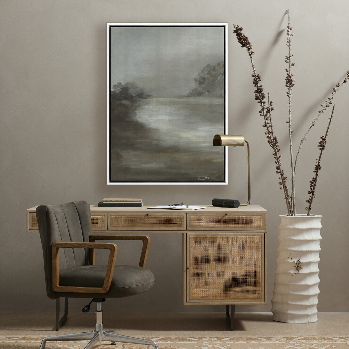 a desk with a chair and a painting on the wall
