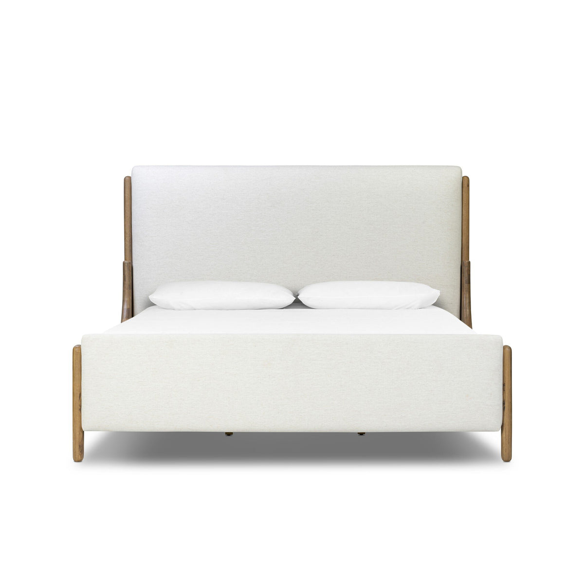 a white bed with wooden legs