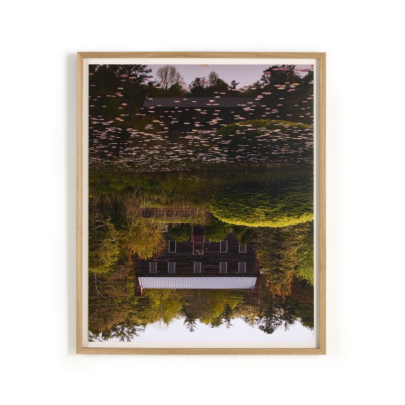 a framed picture of a house and trees