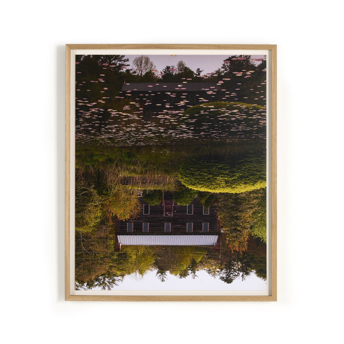 a framed picture of a house and trees