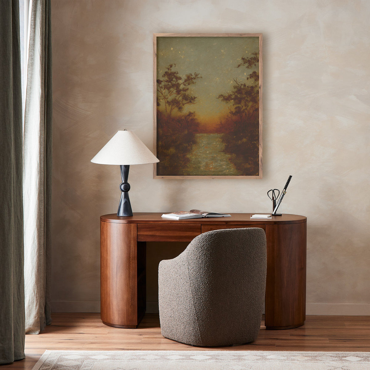 a desk with a lamp and a painting on the wall