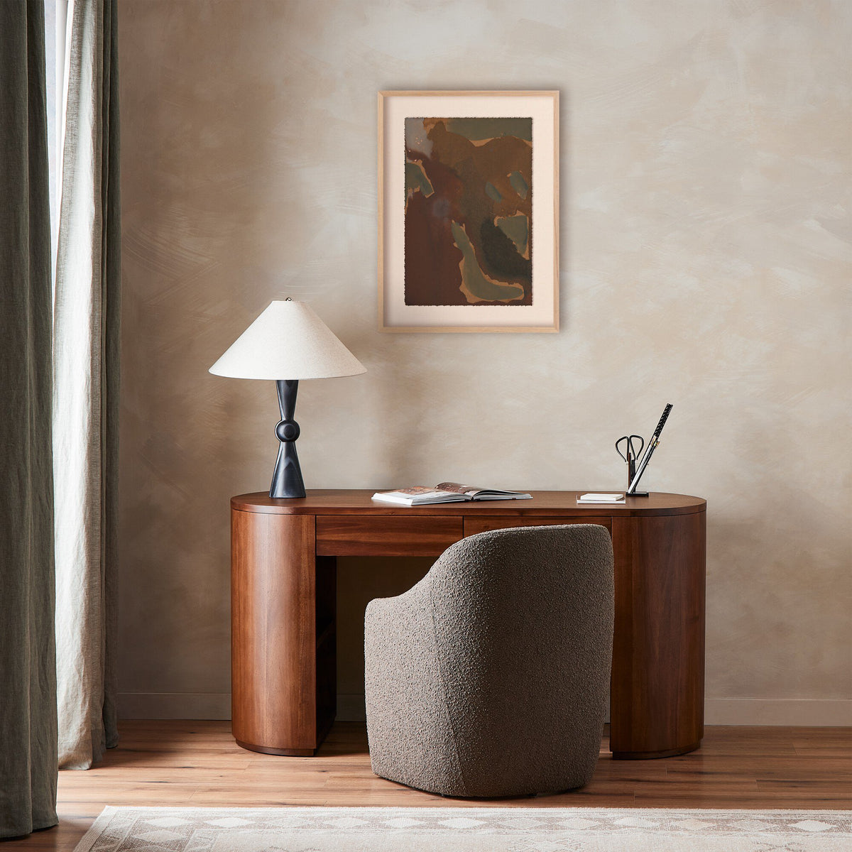 a desk with a lamp and a picture on the wall
