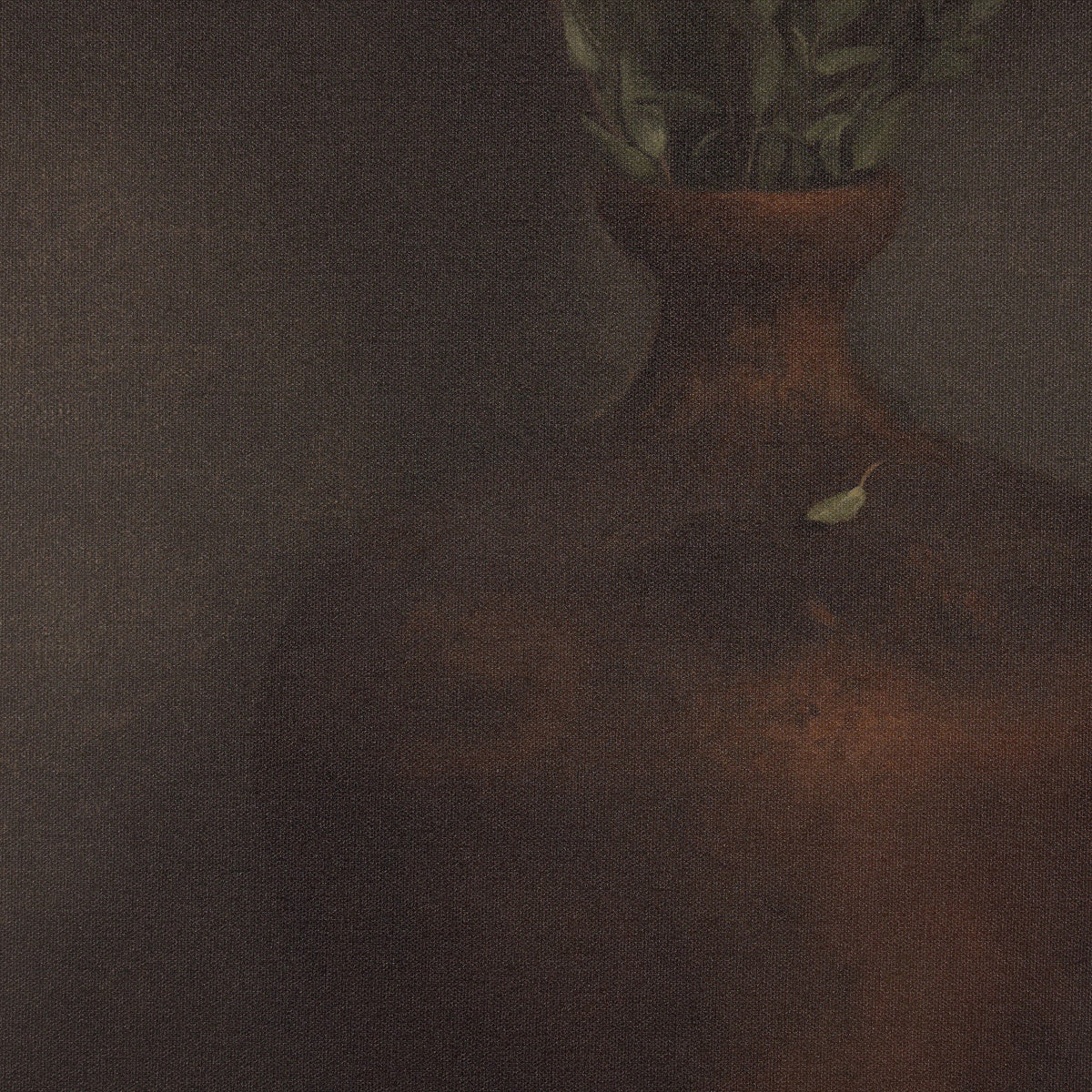 a vase with green leaves