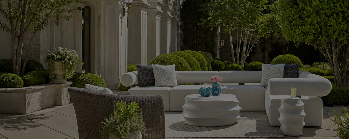 a white couch and a table on a rug outside