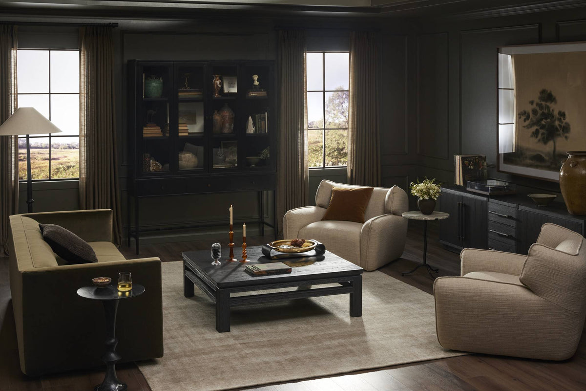 a living room with a black cabinet and chairs