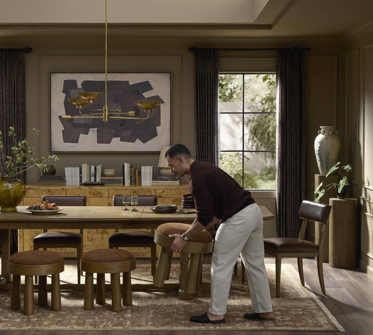 a man standing in a room with a table and chairs