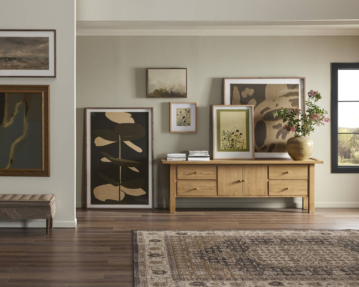 a room with a dresser and pictures on the wall