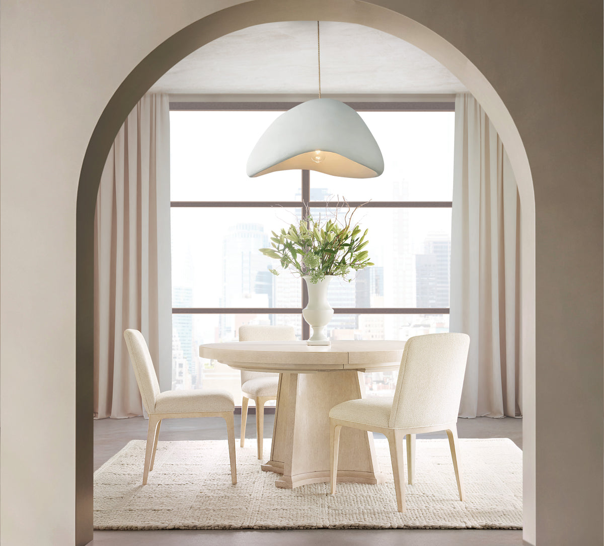 a white table with chairs in a room with a window