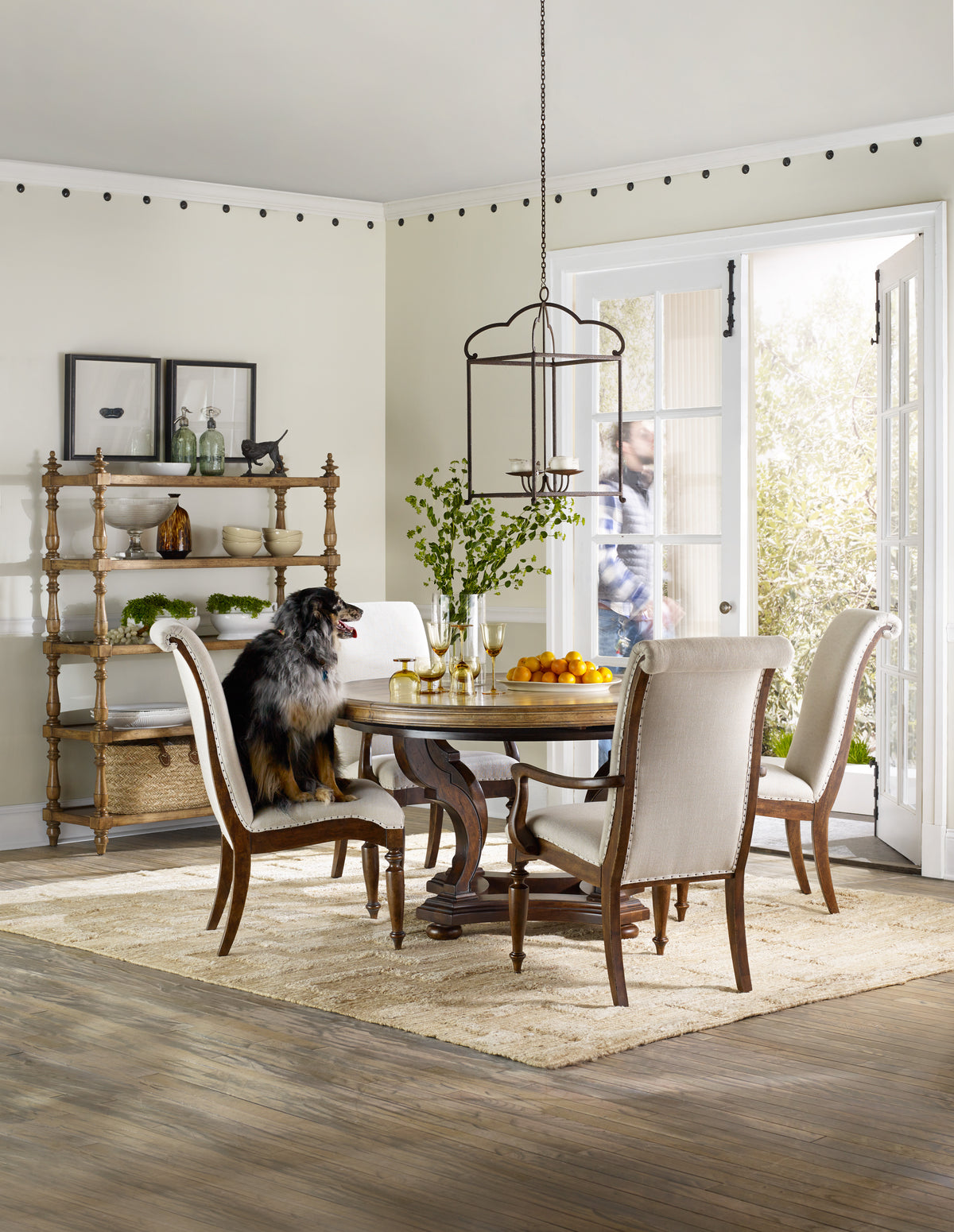 a dog sitting at a table in a room with a table and chairs