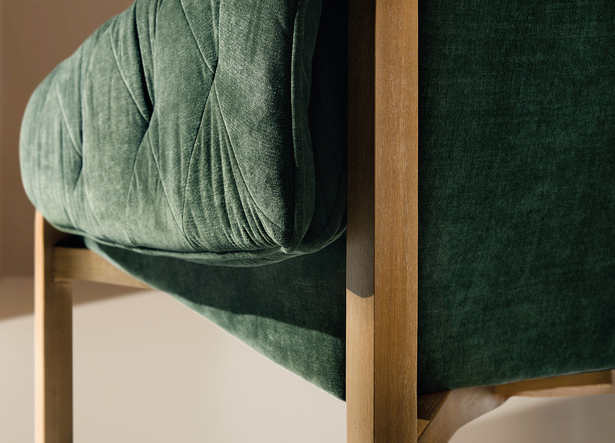 a green couch with wooden legs