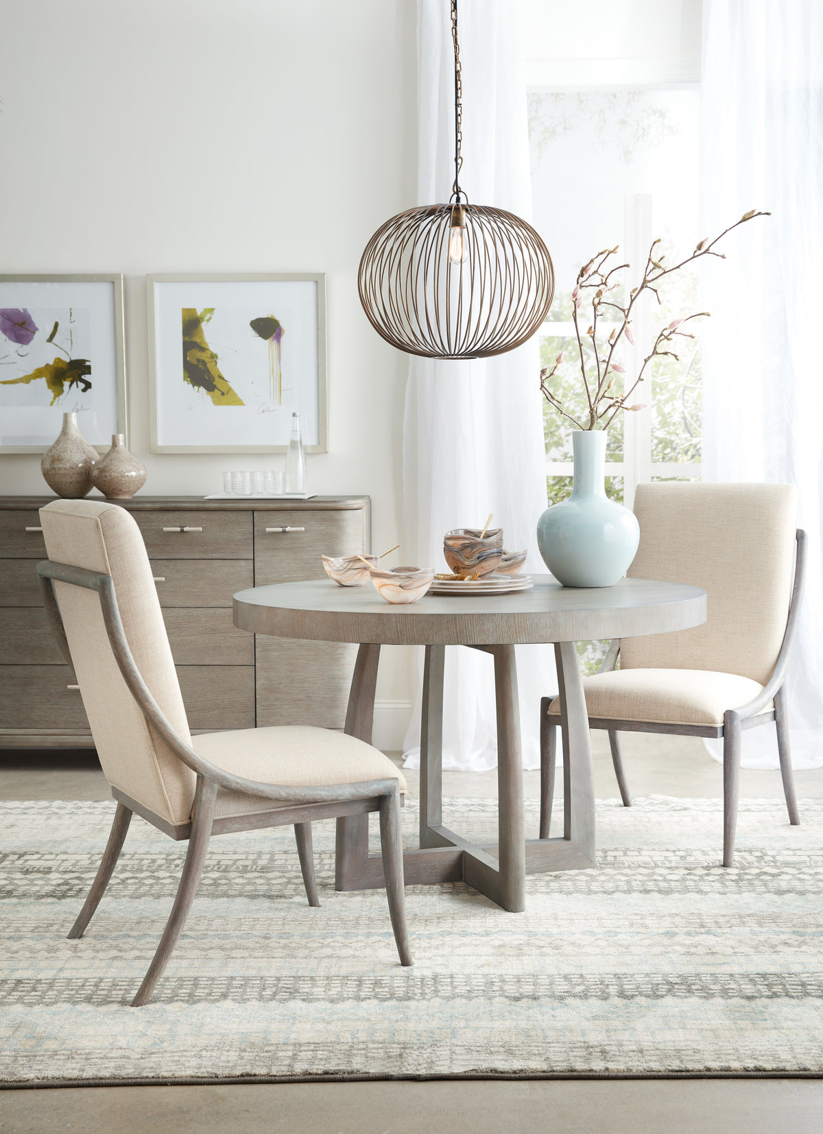 a dining room with a round table and chairs