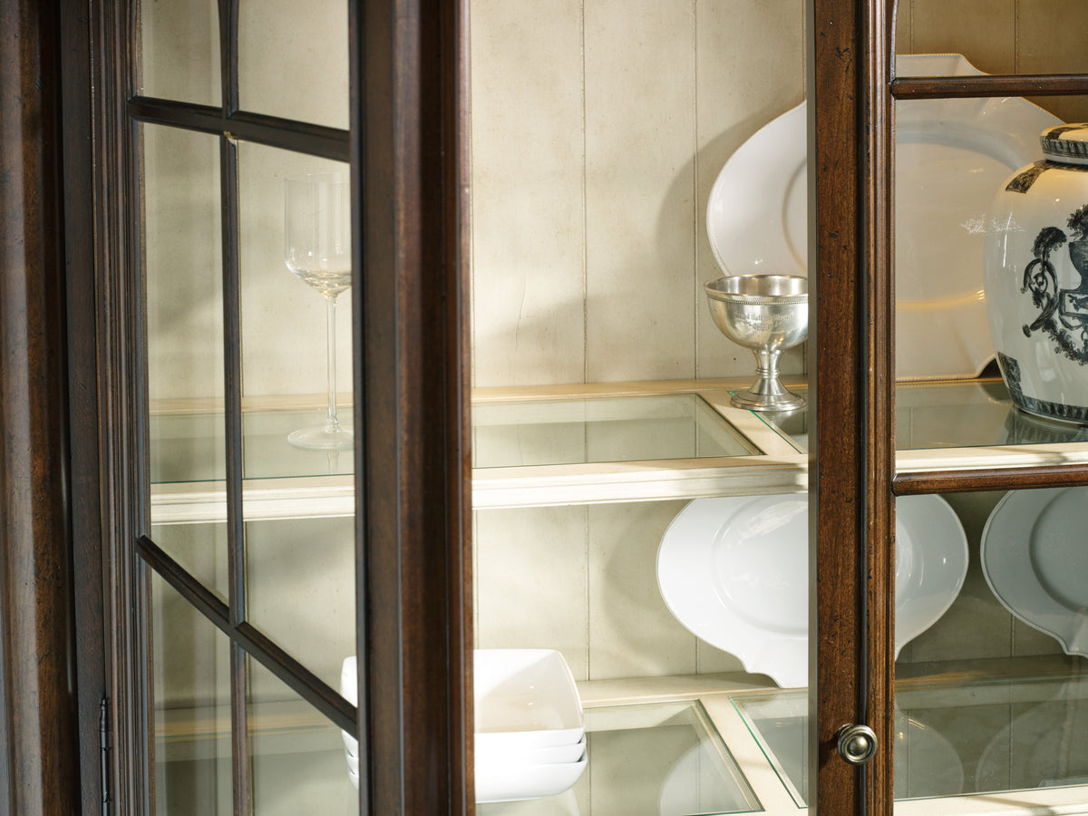 a glass cabinet with plates and glasses