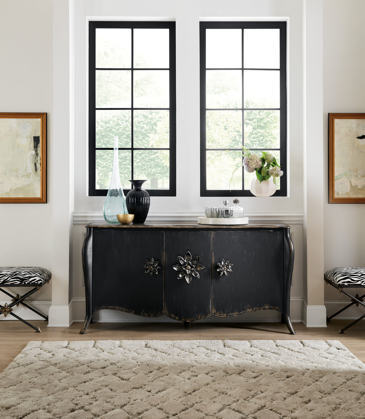 a room with a black dresser and chairs