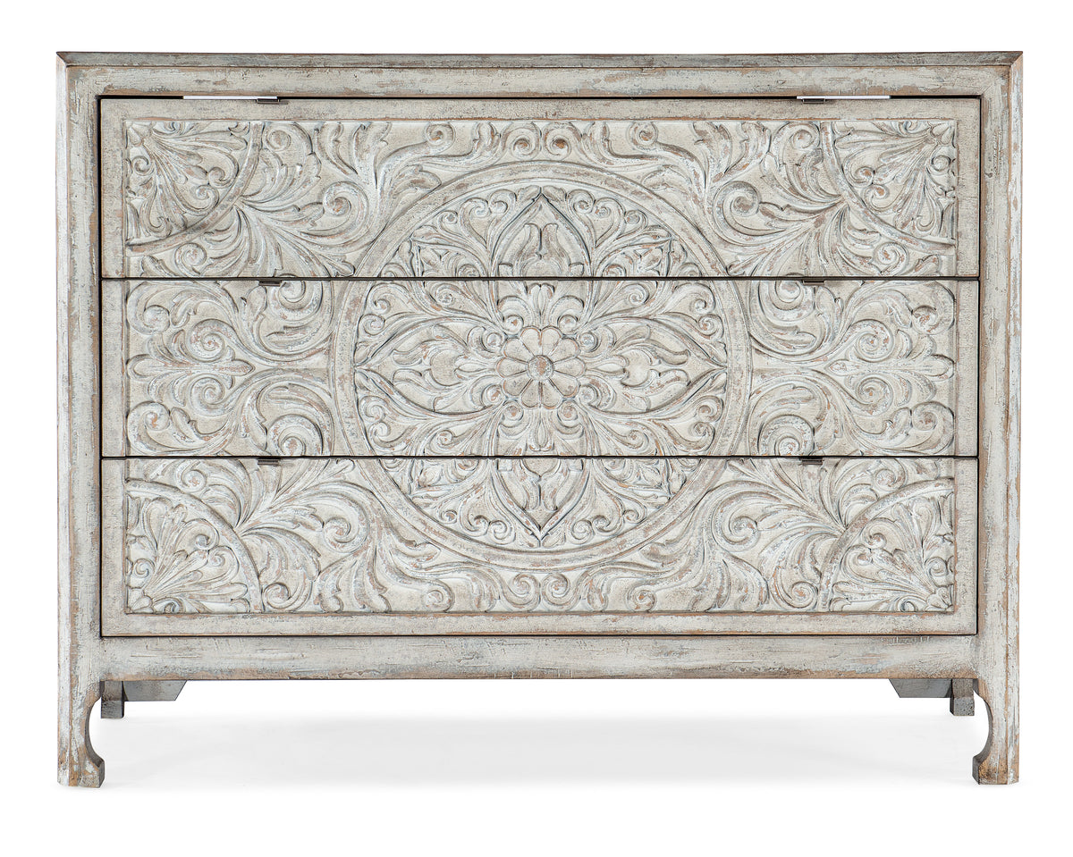 a white wooden chest with carved designs