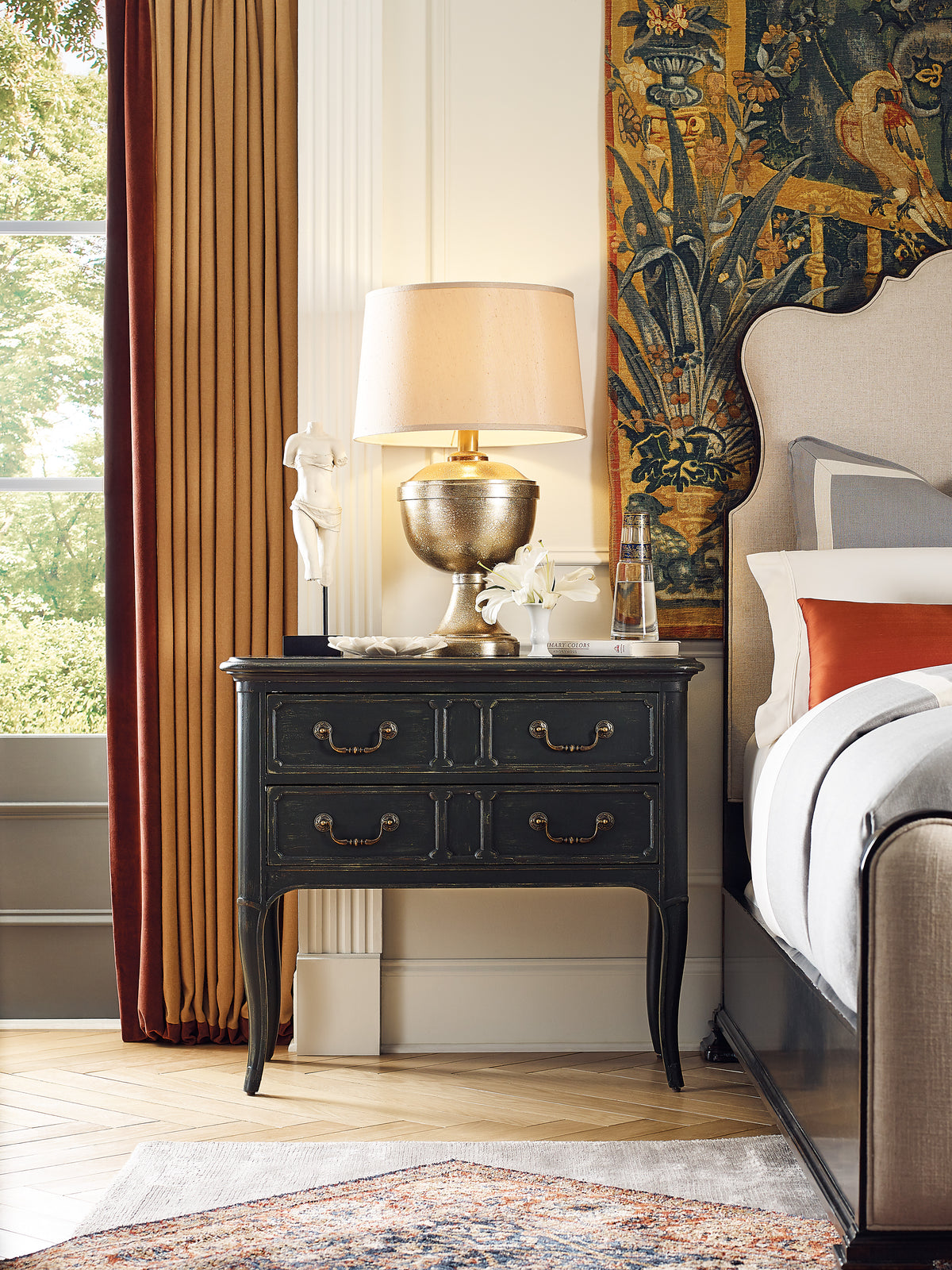 a lamp on a table next to a bed