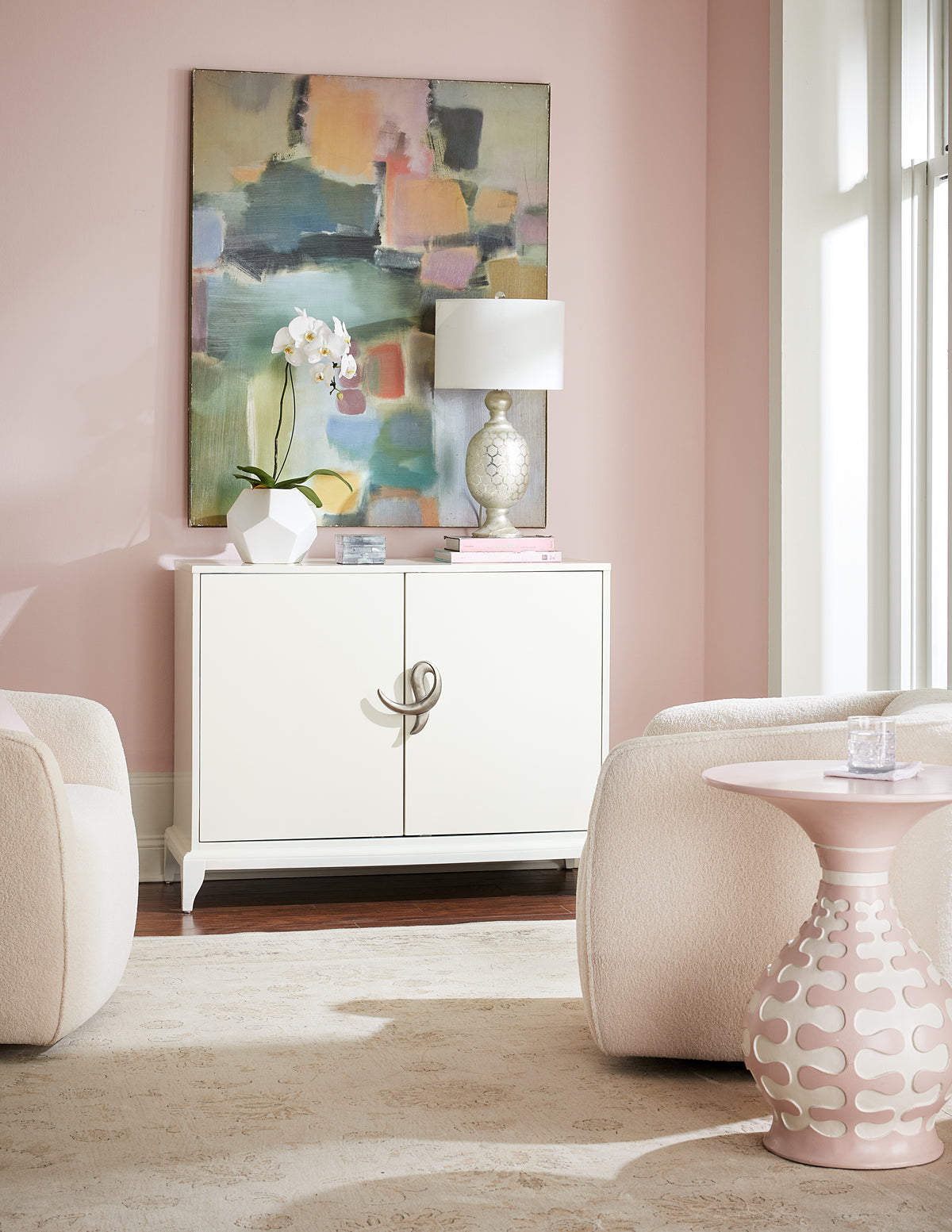 a living room with a painting and a white cabinet