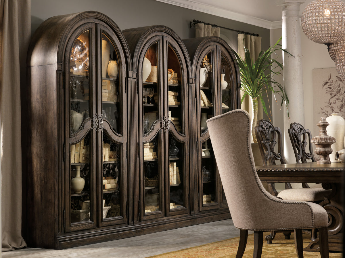 a large cabinet with glass doors and a table and chairs