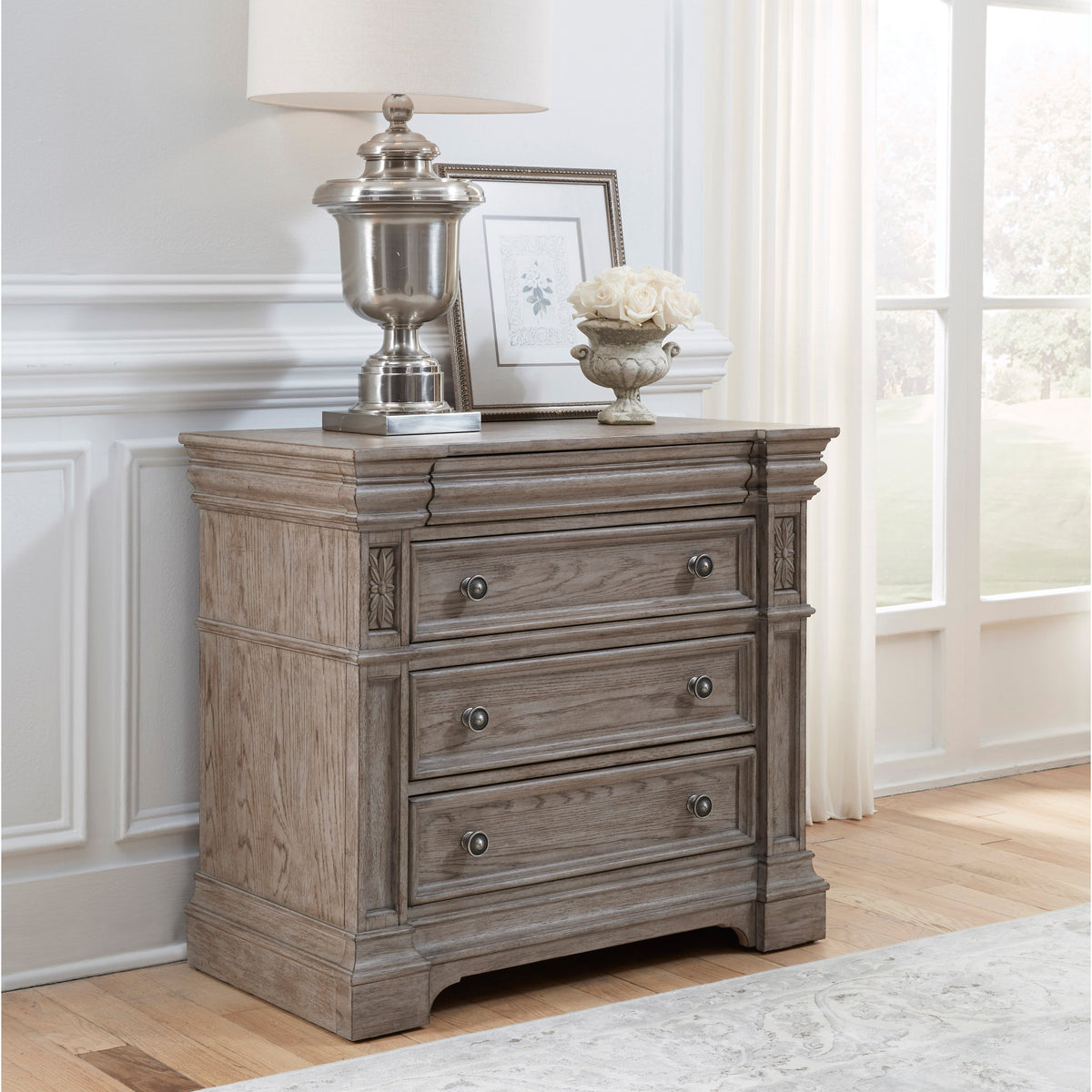 a dresser with a lamp and a picture on it