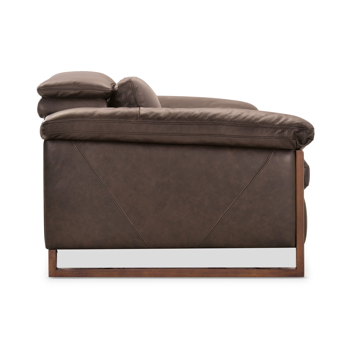 a brown leather couch with wooden legs