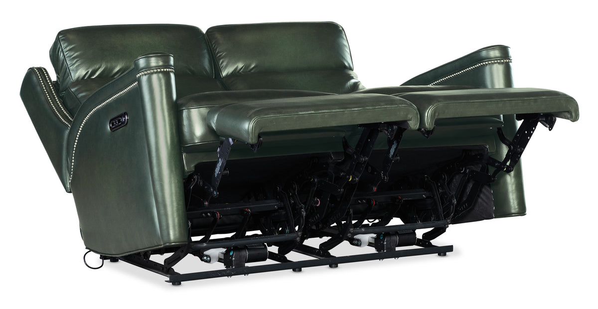 a green leather couch with two recliners