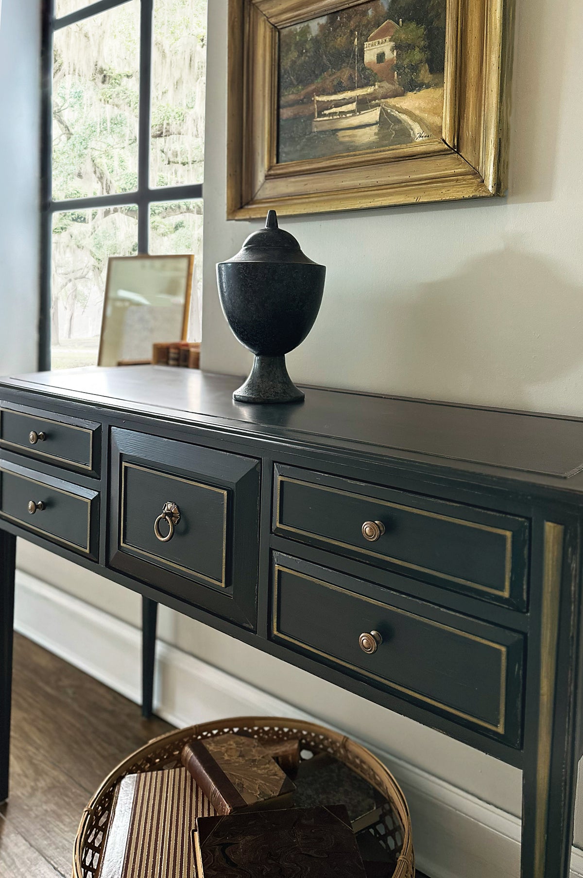 a black table with drawers and a vase on top