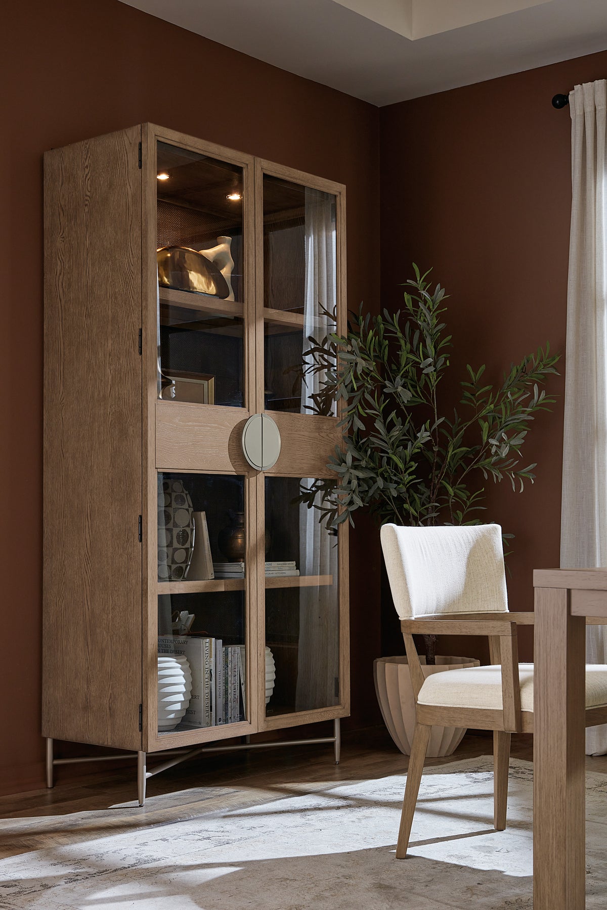 a cabinet with glass doors and a plant in front of it