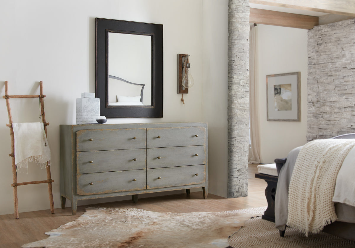 a mirror above a dresser