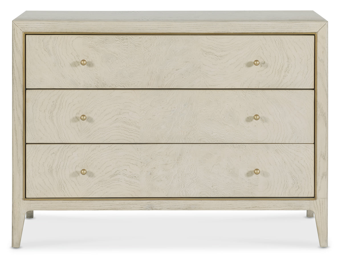 a white dresser with gold knobs