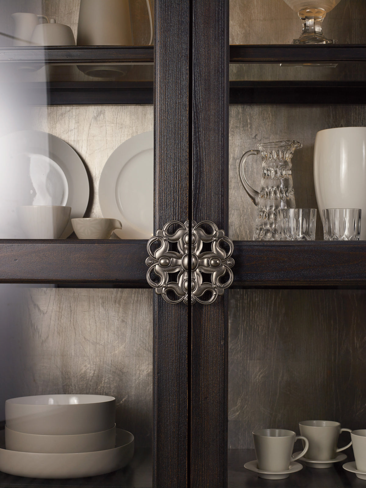 a glass cabinet with plates and cups