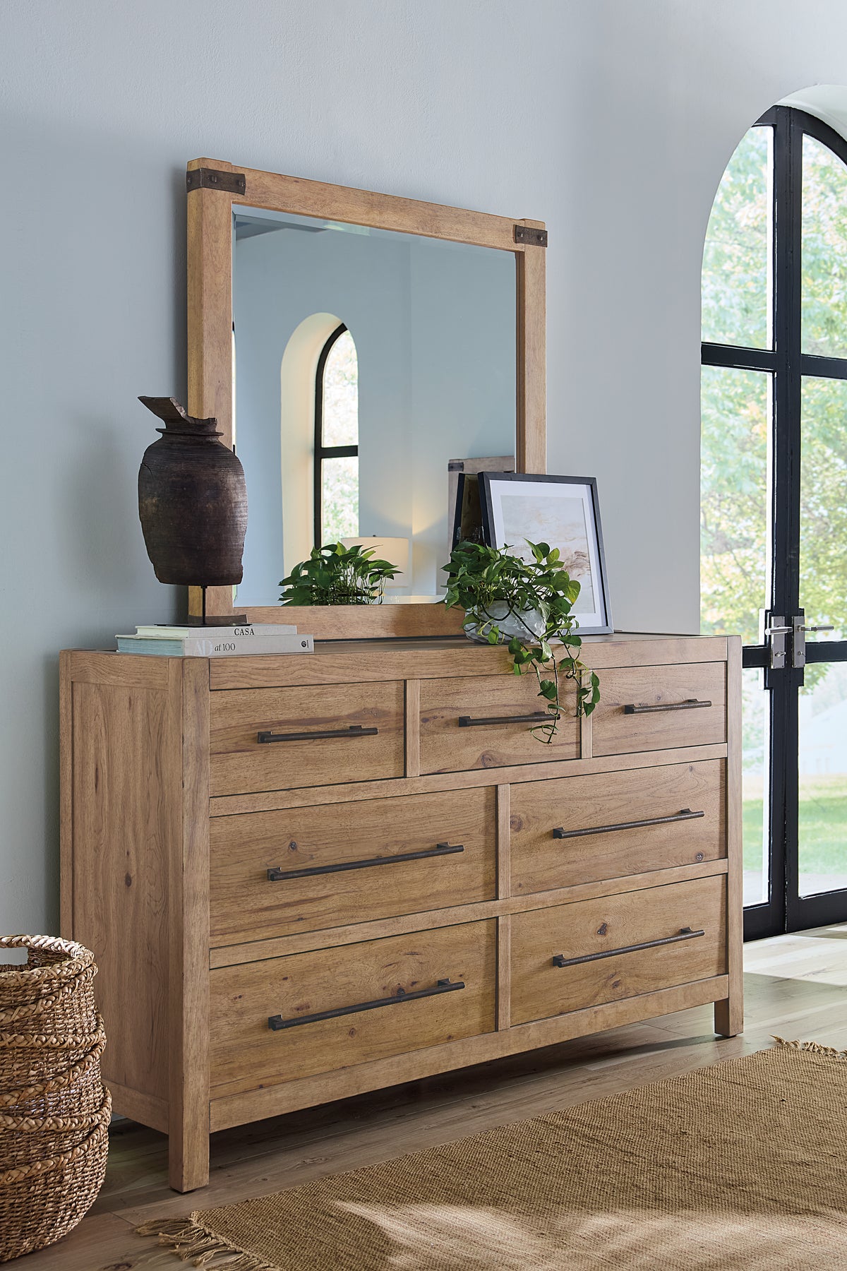 a dresser with a mirror and a plant on top