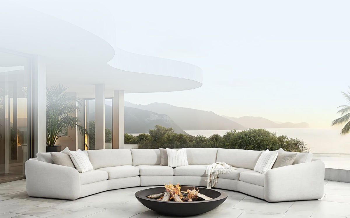 a white couch with a fire pit in front of a large building