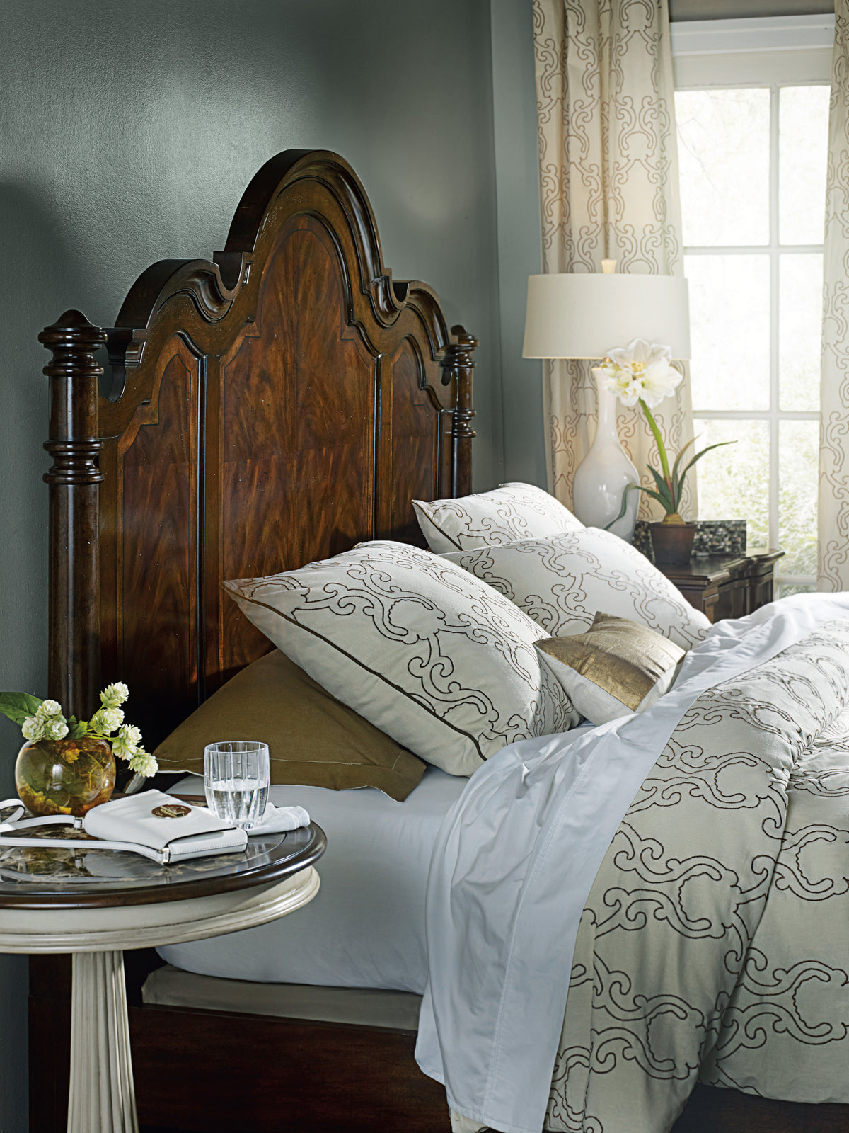 a bed with a wood headboard and a lamp