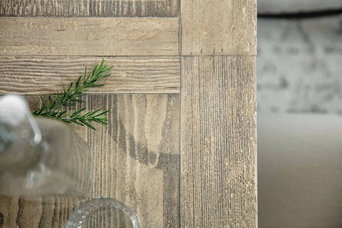 a glass vase and a branch on a wood table