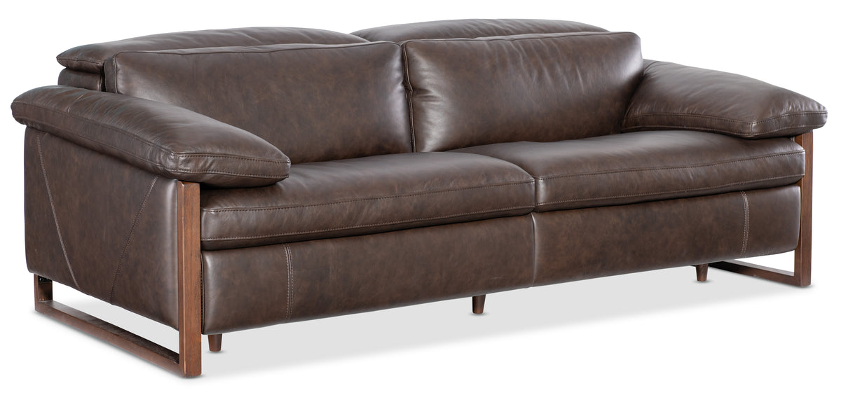 a brown leather couch with two pillows