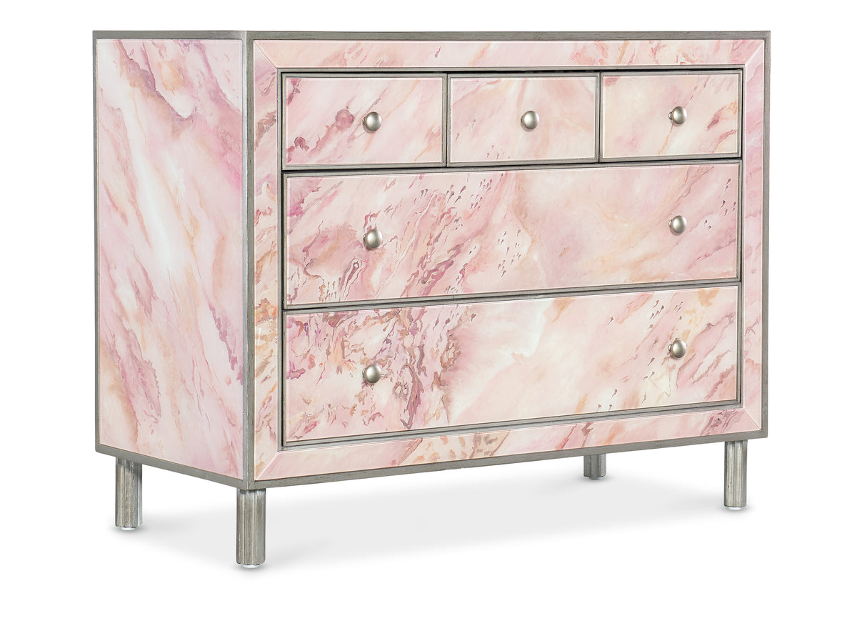 a pink marble dresser with silver legs