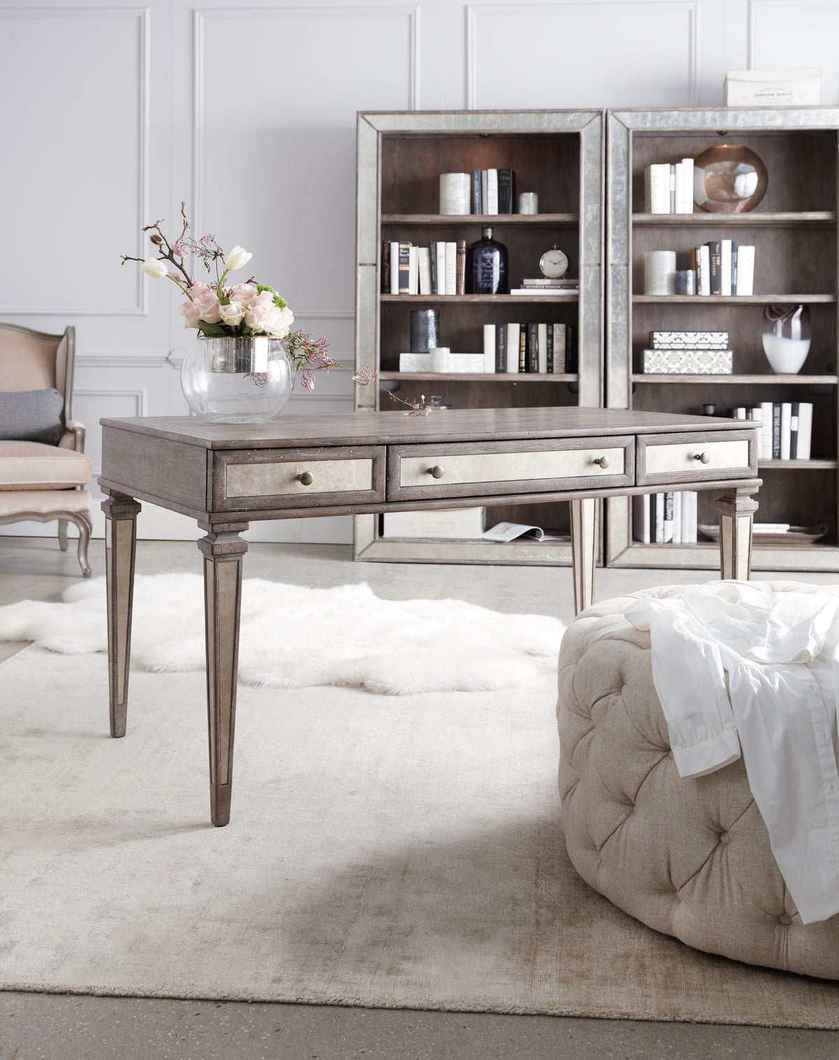 a table in a room with a bookcase and a chair