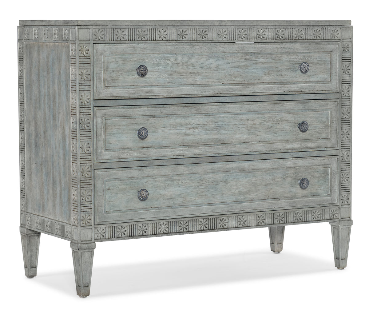 a chest of drawers with carved designs
