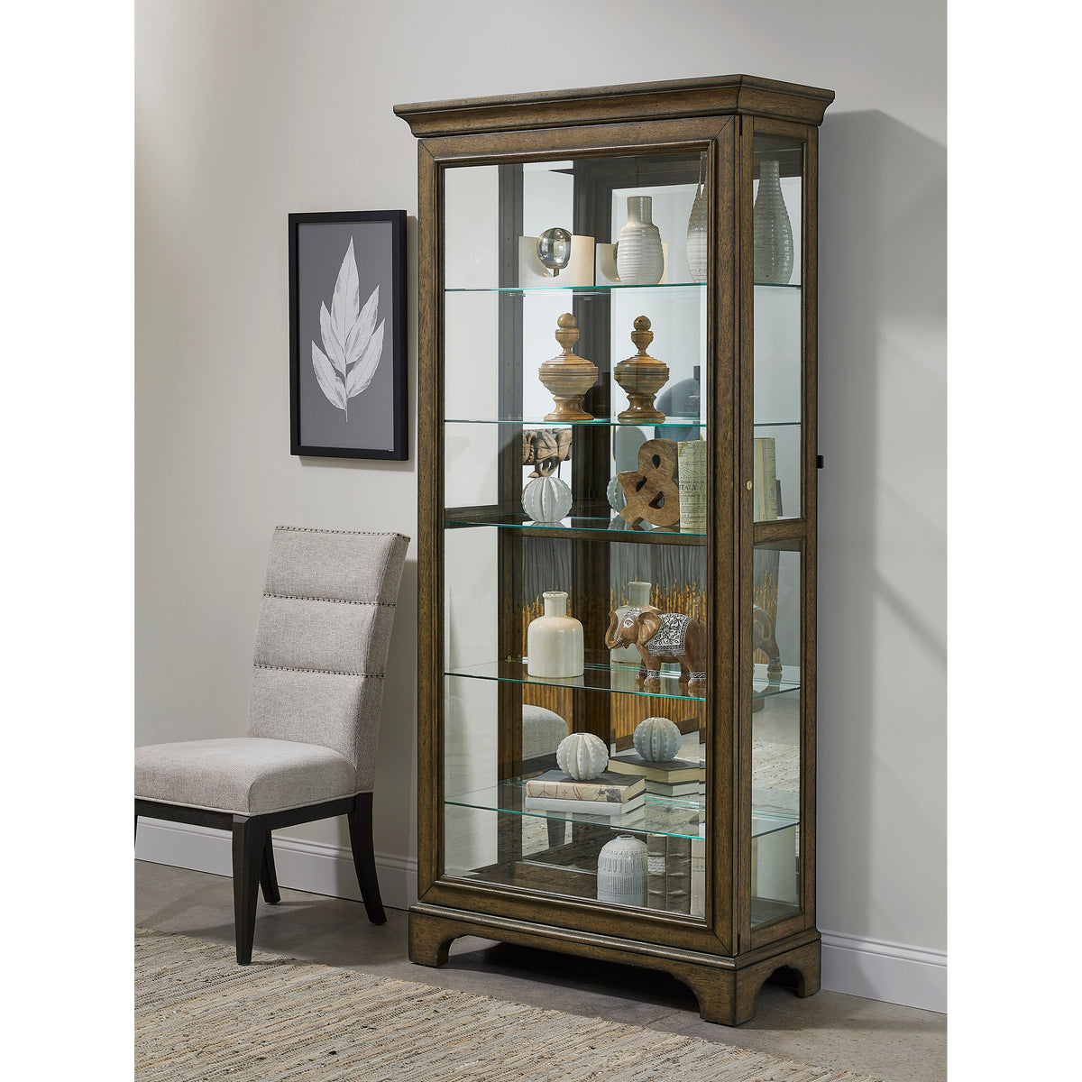a glass cabinet with a chair and a picture on the wall