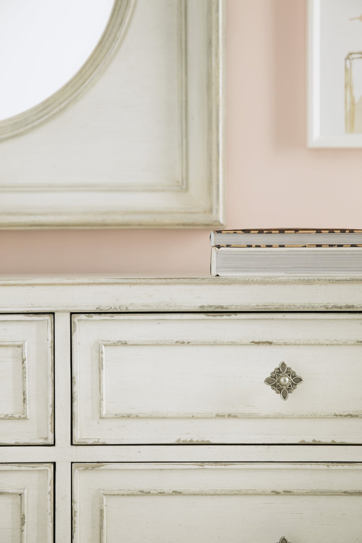 a white dresser with a book on top