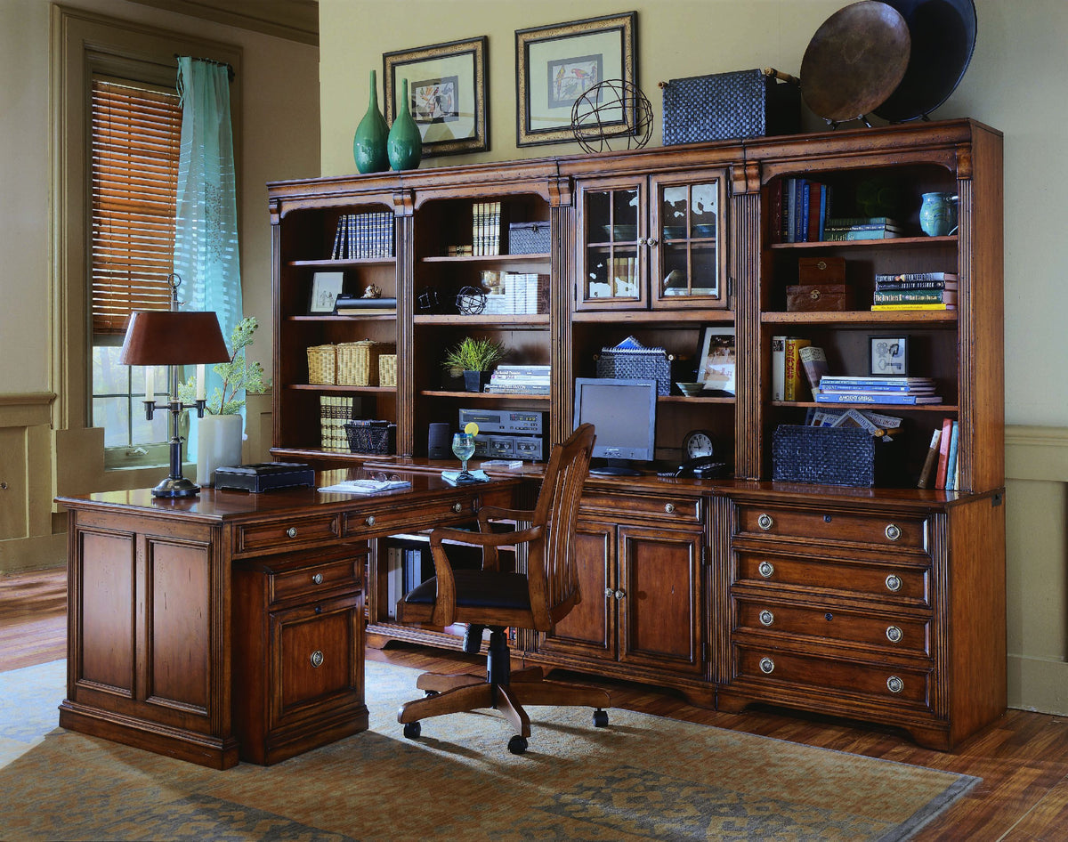 a desk with a computer and a chair in a room