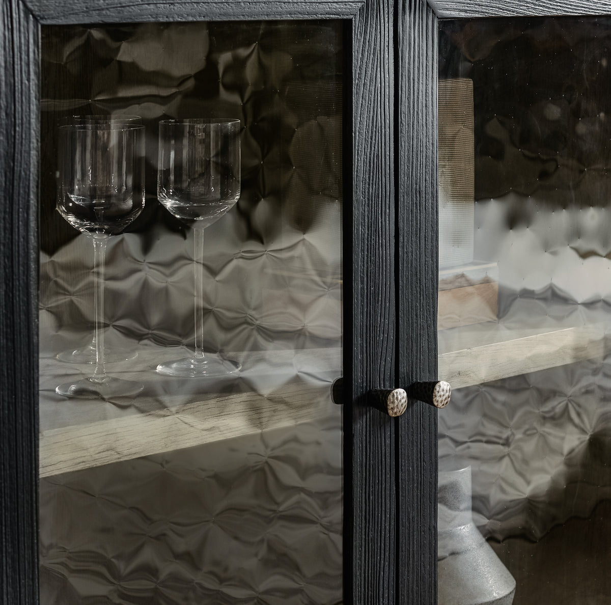 a glass cabinet with a shelf and wine glasses
