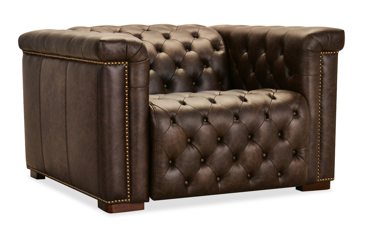 a brown leather couch with gold studs