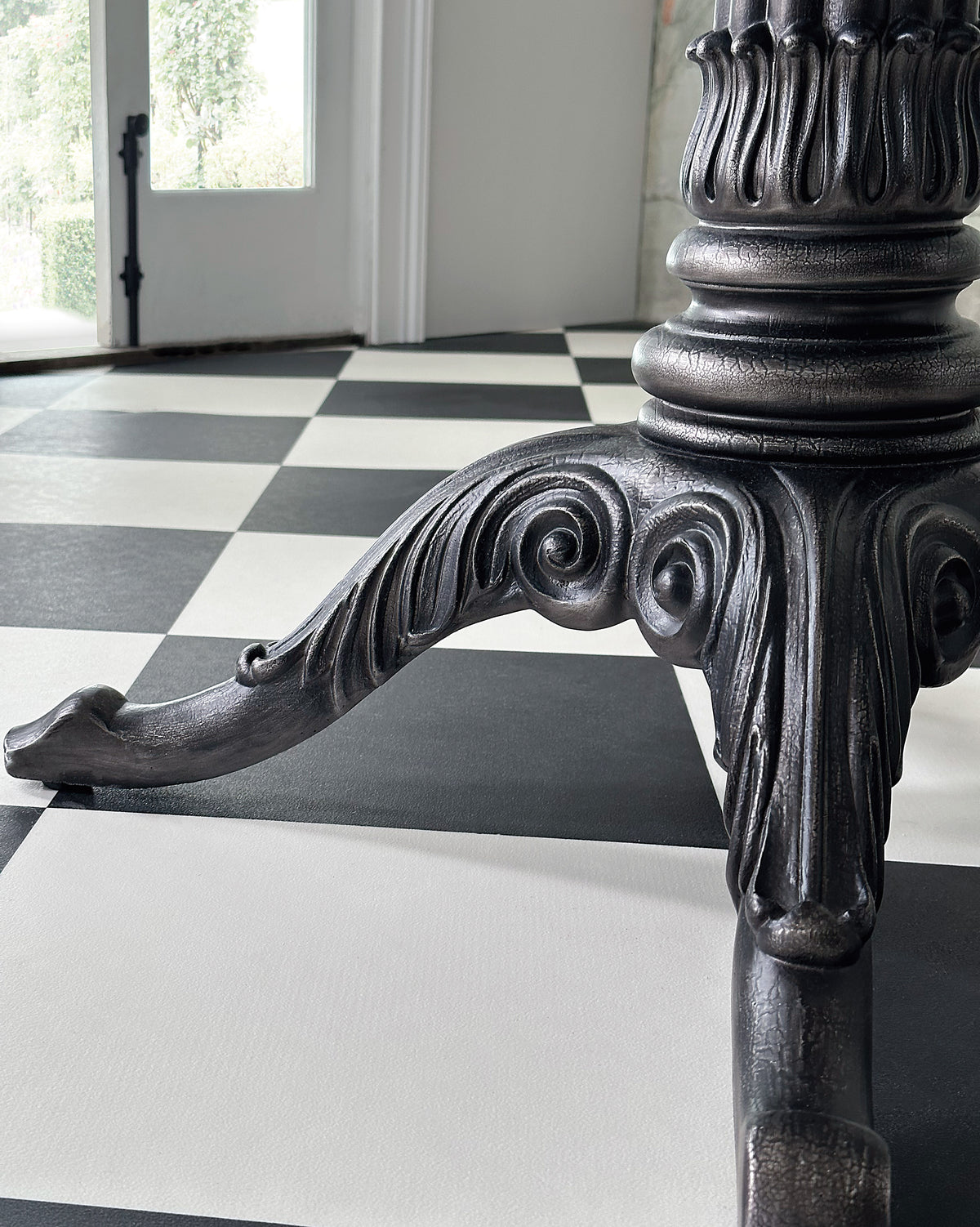 a metal leg on a checkered floor
