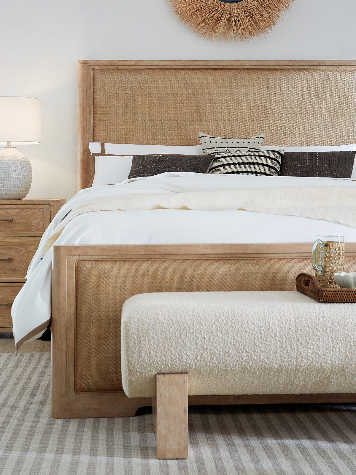 a bed with a rattan headboard and a bench