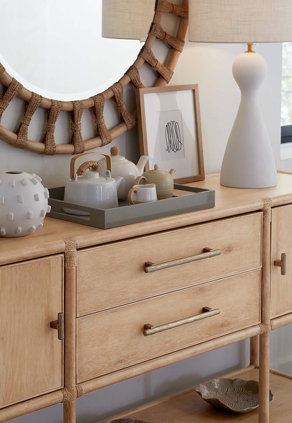 a dresser with a mirror and teapots on it