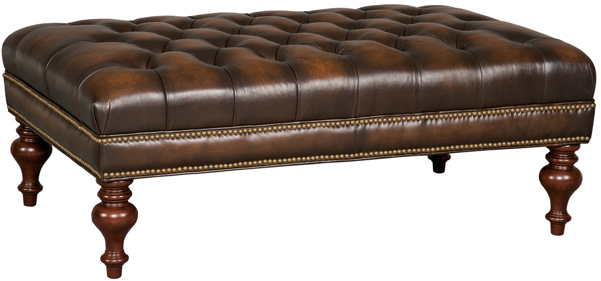 a brown leather ottoman with gold studs