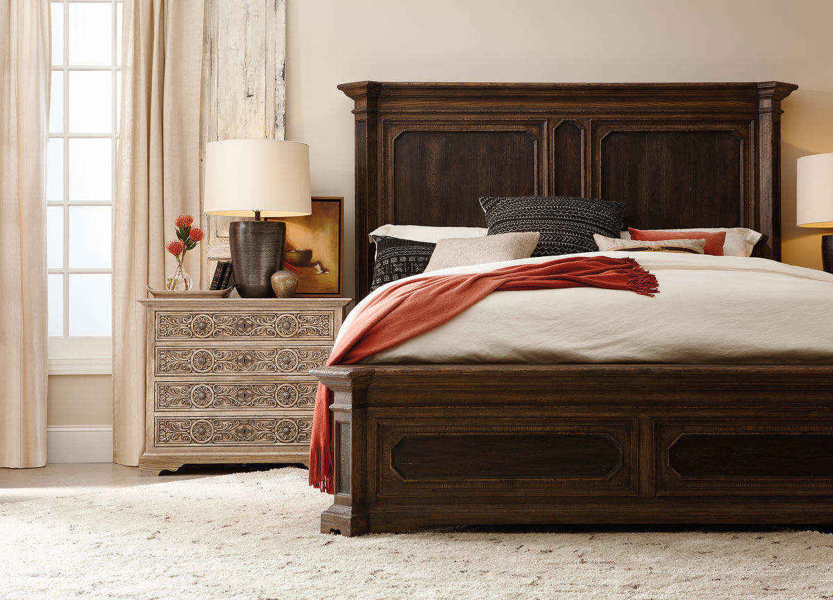 a bed with a wooden headboard and a lamp