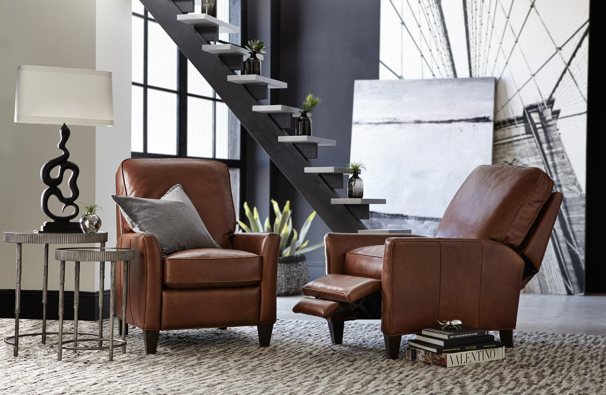 a living room with a staircase and chairs