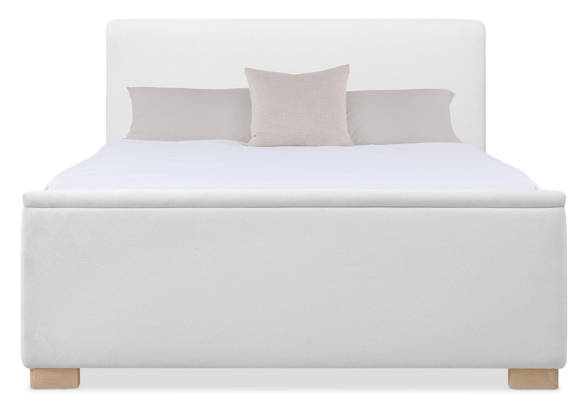 a white bed with a pillow