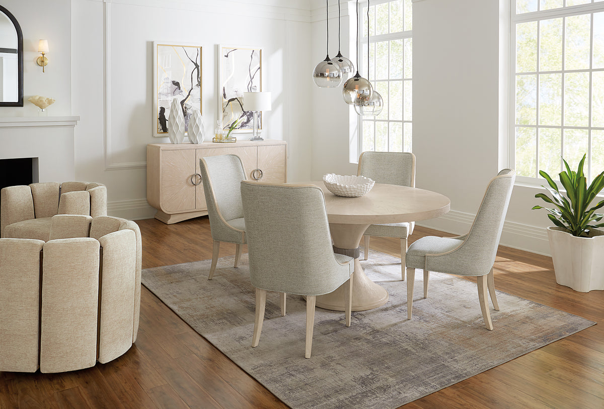 a dining room with a round table and chairs